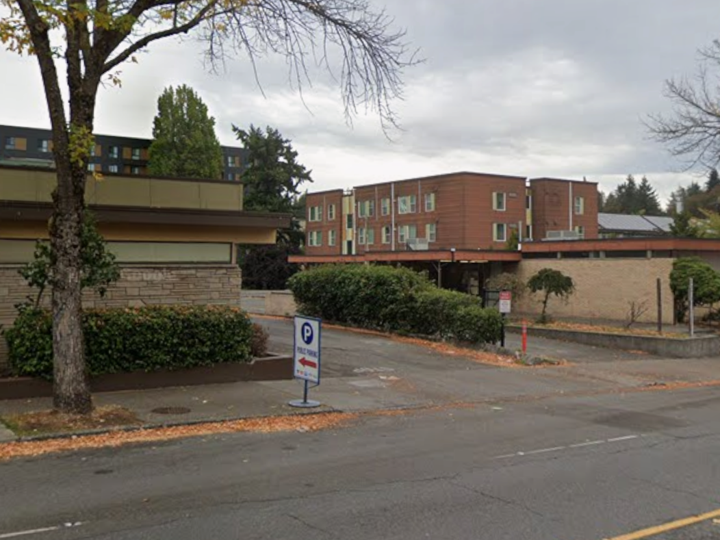 Driveway entrance with parking sign leading to shared lot